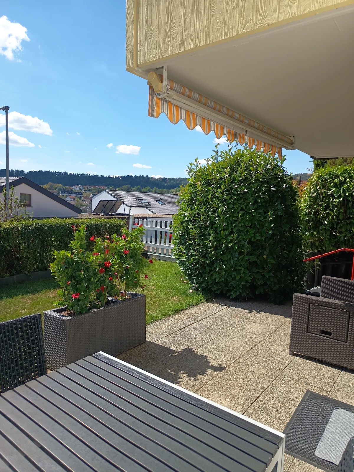 Sonnige Terrasse der Ferienwohnung Kotzor mit Markise, Sitzgelegenheiten und Garten