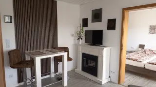 Essbereich der Ferienwohnung mit Hochtisch, Kamin und Fernseher